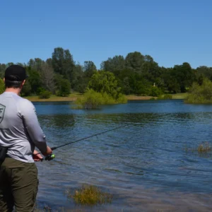 Angler fishing with the EdgeWalker 66MHT travel rod beside a lake
