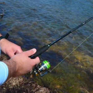 Angler holding the EdgeWalker 66MHT travel rod and spinning reel over clear water