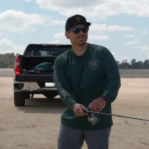 Angler holding the EdgeWalker 66MHT travel rod beside a pickup truck